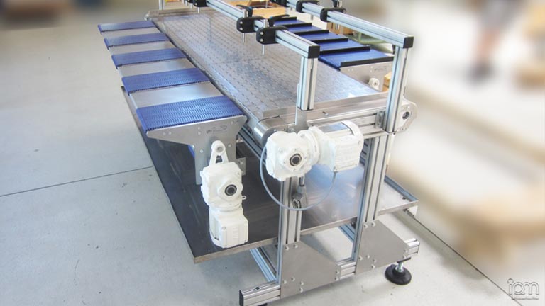 Sie sehen einen Förderer mit Produktaufnahmeträger. Förderer mit Produktaufnahmeträger